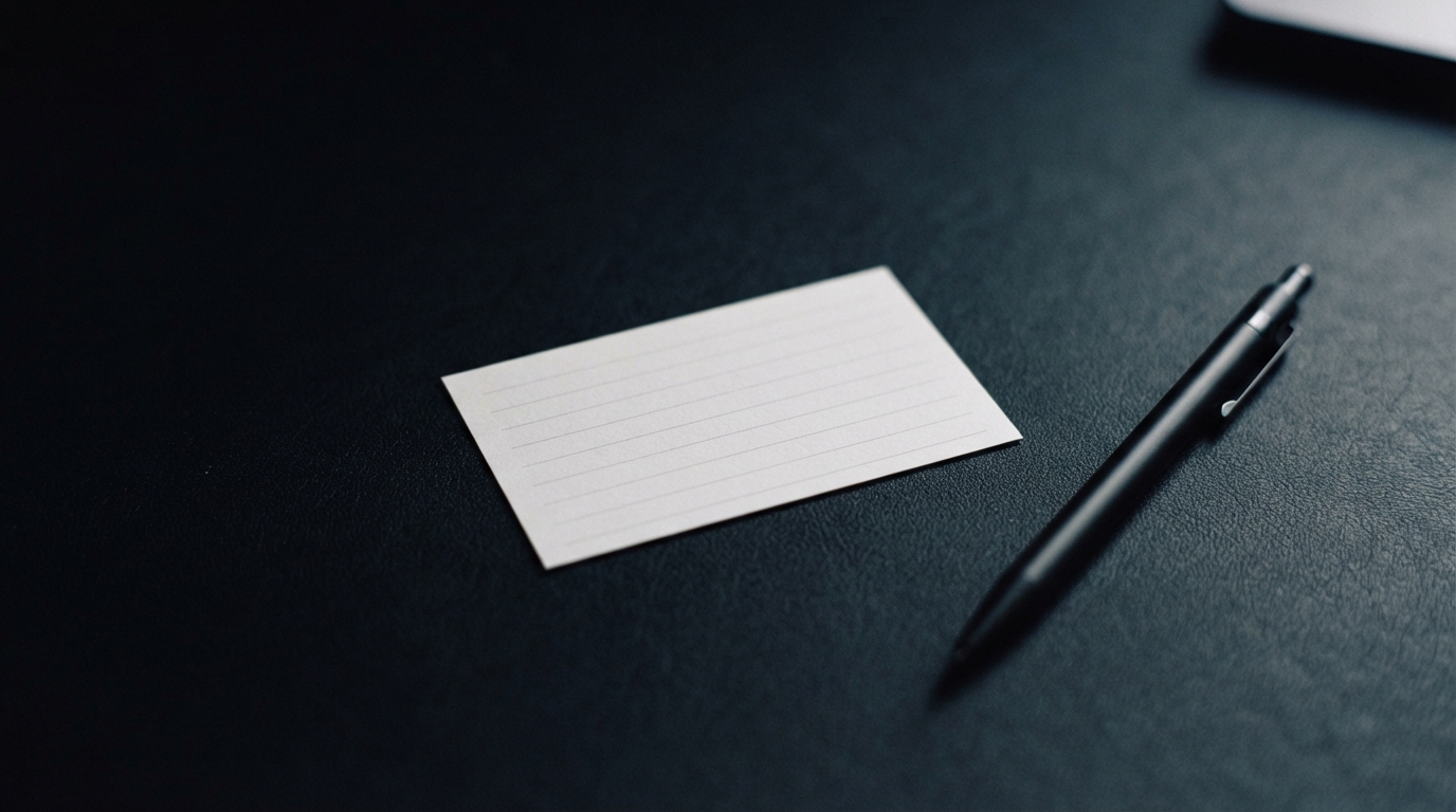 Blank lined card and black pen on a dark textured tabletop.